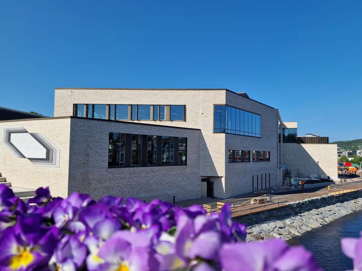 Murbygg med blomster i forgrunnen
